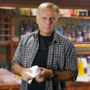 Blond man holding a bar towel